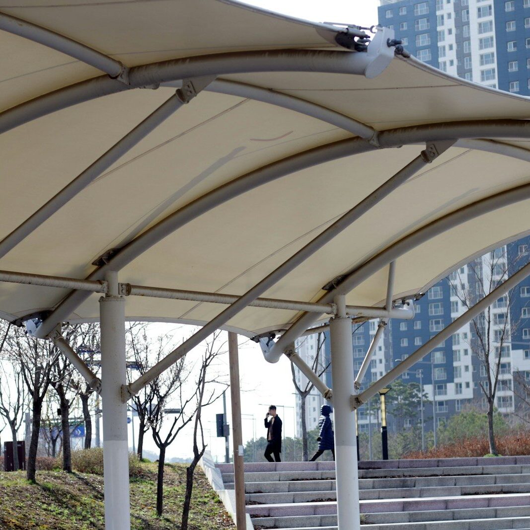 Modern canopy structure with buildings in background